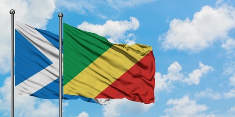 Scotland and Republic Of The Congo flag waving in the wind against white cloudy blue sky together. Diplomacy concept, international relations.