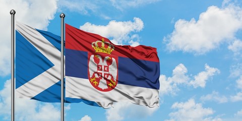 Scotland and Serbia flag waving in the wind against white cloudy blue sky together. Diplomacy concept, international relations.