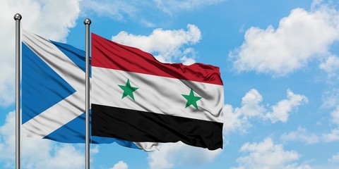 Scotland and Syria flag waving in the wind against white cloudy blue sky together. Diplomacy...