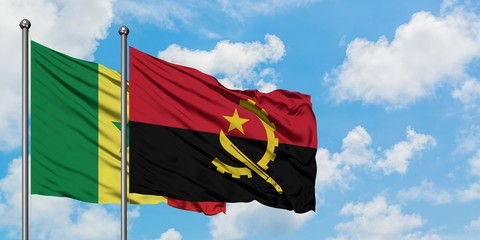 Senegal and Angola flag waving in the wind against white cloudy blue sky together. Diplomacy...