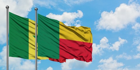 Senegal and Benin flag waving in the wind against white cloudy blue sky together. Diplomacy...