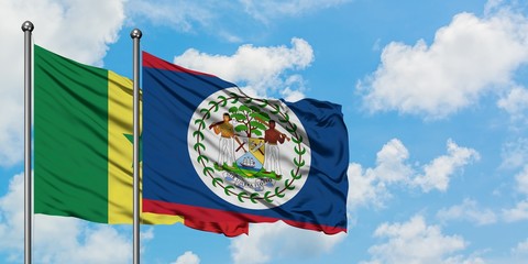 Senegal and Belize flag waving in the wind against white cloudy blue sky together. Diplomacy...