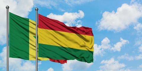 Senegal and Bolivia flag waving in the wind against white cloudy blue sky together. Diplomacy...