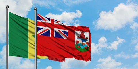 Senegal and Bermuda flag waving in the wind against white cloudy blue sky together. Diplomacy...