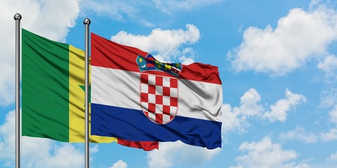 Senegal and Croatia flag waving in the wind against white cloudy blue sky together. Diplomacy...