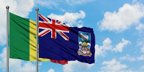 Senegal and Falkland Islands flag waving in the wind against white cloudy blue sky together....