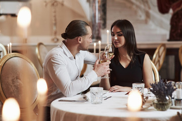 Guy make party for the girl. Beautiful couple have romantic dinner in luxury restaurant at evening time