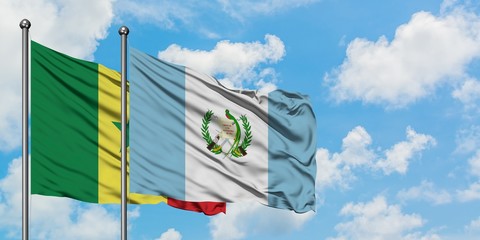 Senegal and Guatemala flag waving in the wind against white cloudy blue sky together. Diplomacy...