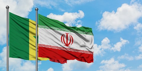 Senegal and Iran flag waving in the wind against white cloudy blue sky together. Diplomacy concept,...