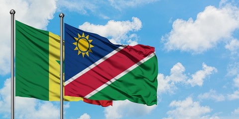 Senegal and Namibia flag waving in the wind against white cloudy blue sky together. Diplomacy concept, international relations.