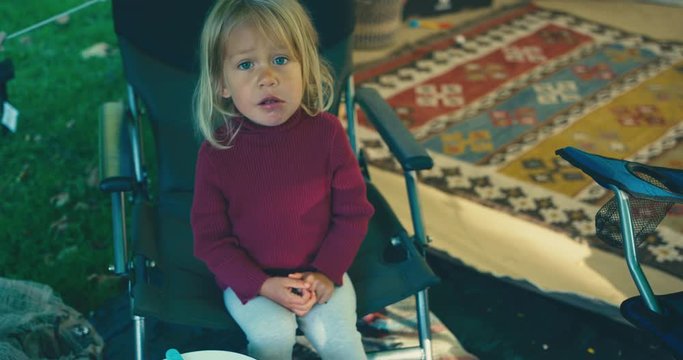 Little toddler sitting on chair in luxury tent