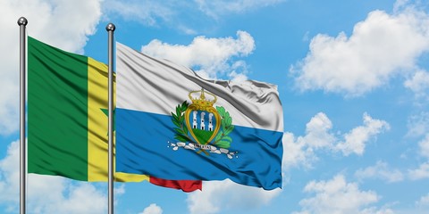 Senegal and San Marino flag waving in the wind against white cloudy blue sky together. Diplomacy concept, international relations.