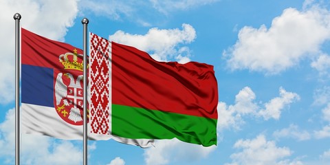 Serbia and Belarus flag waving in the wind against white cloudy blue sky together. Diplomacy concept, international relations.