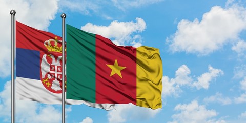 Serbia and Cameroon flag waving in the wind against white cloudy blue sky together. Diplomacy concept, international relations.