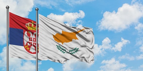 Serbia and Cyprus flag waving in the wind against white cloudy blue sky together. Diplomacy...