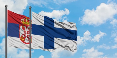Serbia and Finland flag waving in the wind against white cloudy blue sky together. Diplomacy...