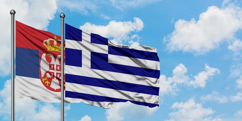 Serbia and Greece flag waving in the wind against white cloudy blue sky together. Diplomacy concept, international relations.