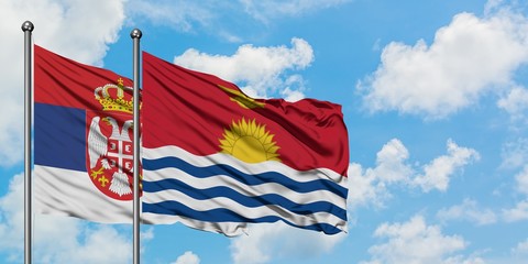 Serbia and Kiribati flag waving in the wind against white cloudy blue sky together. Diplomacy concept, international relations.