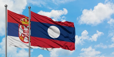 Serbia and Laos flag waving in the wind against white cloudy blue sky together. Diplomacy concept,...
