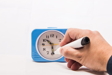 The marker on the dial of the alarm clock writes the word