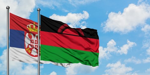 Serbia and Malawi flag waving in the wind against white cloudy blue sky together. Diplomacy concept, international relations.