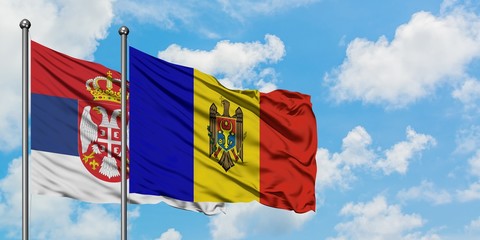Serbia and Moldova flag waving in the wind against white cloudy blue sky together. Diplomacy concept, international relations.