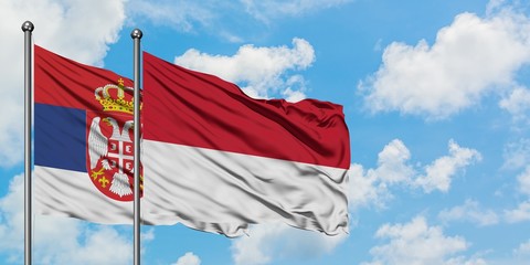 Serbia and Monaco flag waving in the wind against white cloudy blue sky together. Diplomacy concept, international relations.