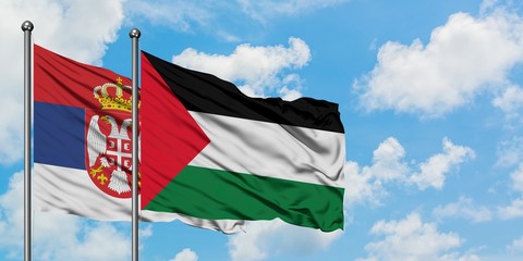 Naklejka na ściany i meble Serbia and Palestine flag waving in the wind against white cloudy blue sky together. Diplomacy concept, international relations.