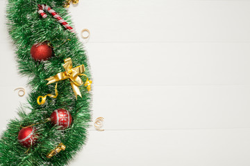 Christmas background for the inscription, decorated with green garland and Christmas toys, the background is white, there is a place for the inscription. The concept of Christmas or New year.