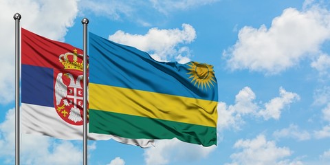 Serbia and Rwanda flag waving in the wind against white cloudy blue sky together. Diplomacy concept, international relations.