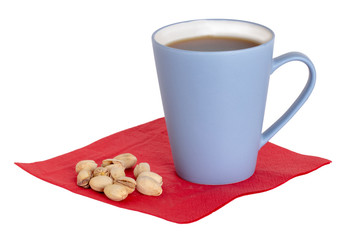 Coffee cup background isolated. Close-up of a blue coffee mug and pistachios on a red napkin isolated on a white background. Concept morning coffee. Macro.