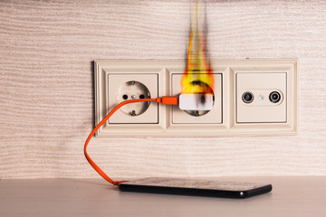 The charger of the mobile phone caught fire in the socket.
