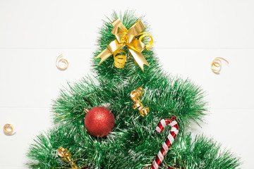 Christmas tree decorative with Christmas toys, made of garland on a white background, there is a place for the inscription. The concept of a New year or Christmas.