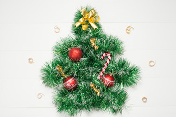 Christmas tree decorative with Christmas toys, made of garland on a white background, there is a place for the inscription. The concept of a New year or Christmas.