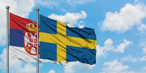Serbia and Sweden flag waving in the wind against white cloudy blue sky together. Diplomacy...