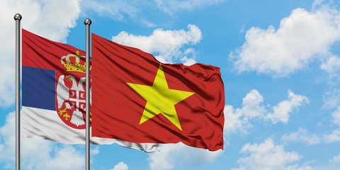 Serbia and Vietnam flag waving in the wind against white cloudy blue sky together. Diplomacy...