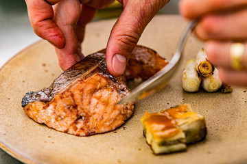 Close up hands of chef preparing food in the kitchen of a restaurant, cooking concept