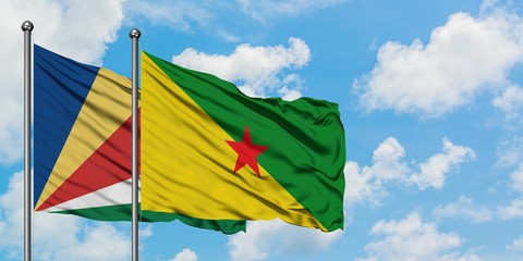 Seychelles and French Guiana flag waving in the wind against white cloudy blue sky together. Diplomacy concept, international relations.