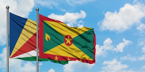 Seychelles and Grenada flag waving in the wind against white cloudy blue sky together. Diplomacy concept, international relations.
