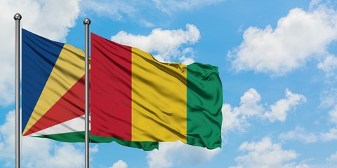 Seychelles and Guinea flag waving in the wind against white cloudy blue sky together. Diplomacy concept, international relations.