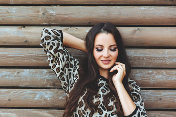 Beautiful girl portrait outside , long hair ,she is smiling on wood background, fashionable look