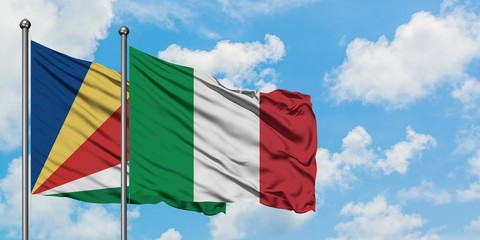 Seychelles and Italy flag waving in the wind against white cloudy blue sky together. Diplomacy...