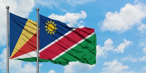 Seychelles and Namibia flag waving in the wind against white cloudy blue sky together. Diplomacy concept, international relations.