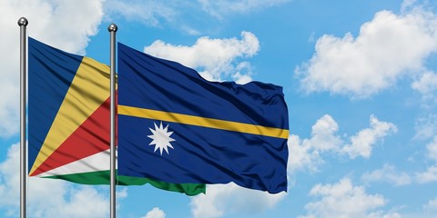Seychelles and Nauru flag waving in the wind against white cloudy blue sky together. Diplomacy...