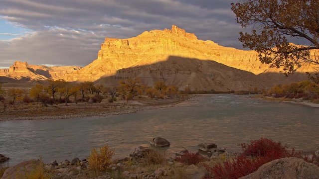 Desert cliffs lit up by the sun during sunrise along the green river next to swaseys beach.