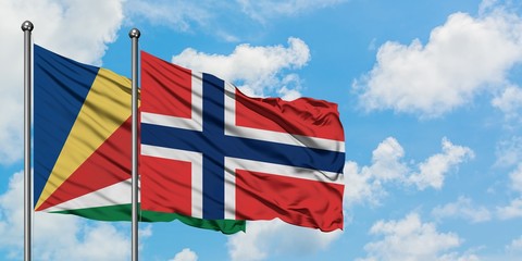 Seychelles and Norway flag waving in the wind against white cloudy blue sky together. Diplomacy concept, international relations.