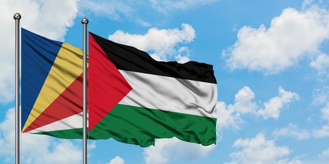 Seychelles and Palestine flag waving in the wind against white cloudy blue sky together. Diplomacy concept, international relations.