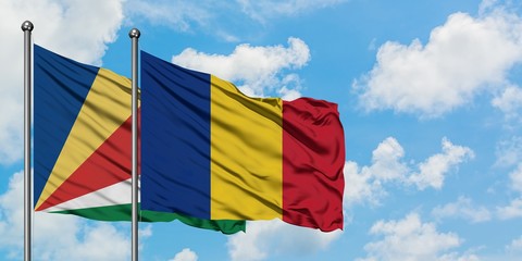 Seychelles and Romania flag waving in the wind against white cloudy blue sky together. Diplomacy concept, international relations.