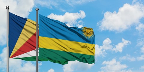 Seychelles and Rwanda flag waving in the wind against white cloudy blue sky together. Diplomacy concept, international relations.
