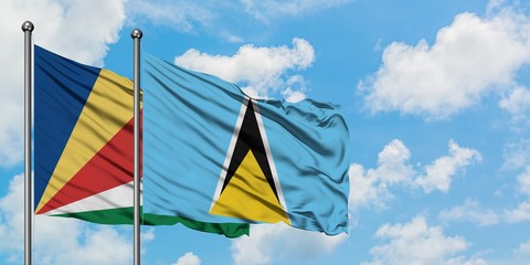 Seychelles and Saint Lucia flag waving in the wind against white cloudy blue sky together....